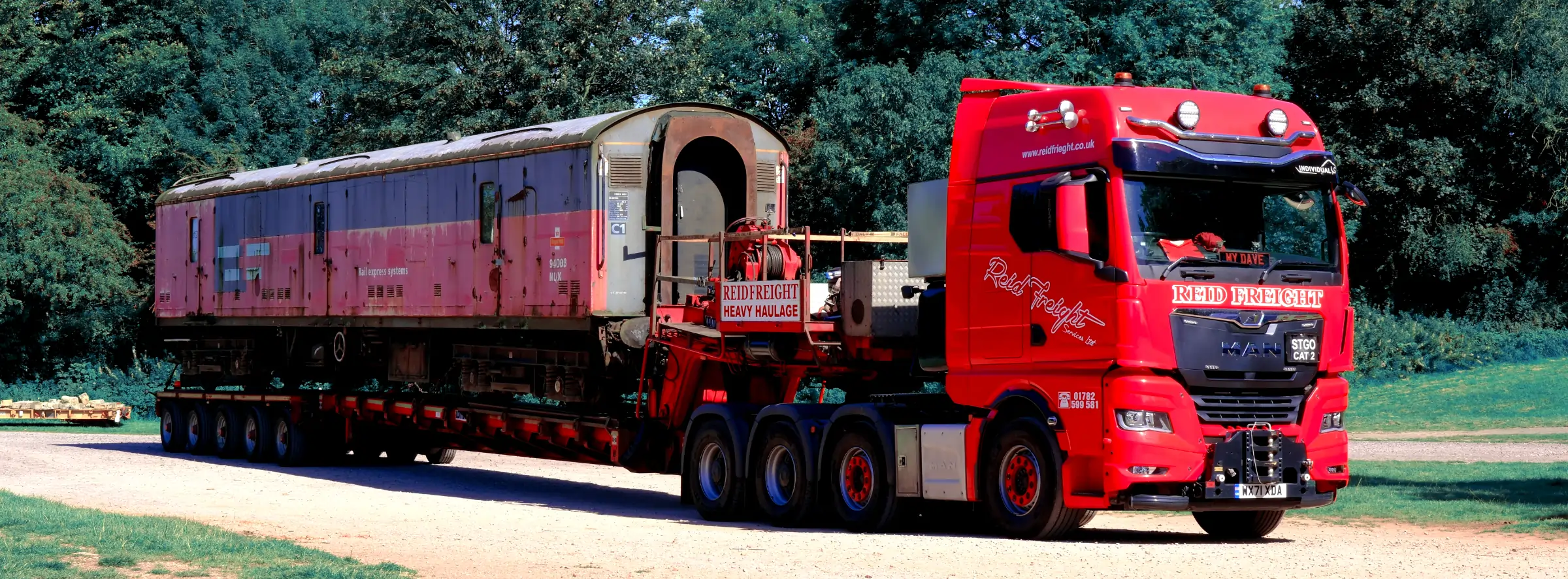 Red train car on red trailer truck.